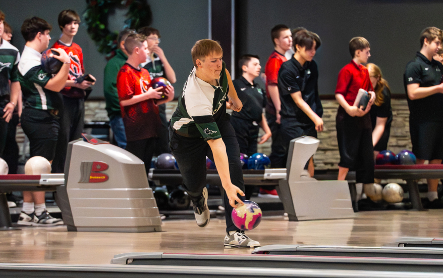Boy releasing bowling ball